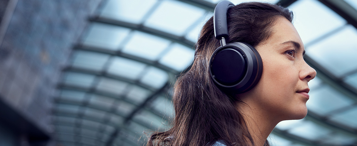 Nő &eacute;lvezi a zen&eacute;t utaz&aacute;s k&ouml;zben Philips L4 fejhallgat&oacute;val
